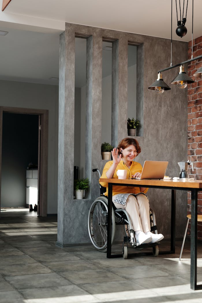 Home Woman in a wheelchair enjoying remote work and video call at home in a modern interior.